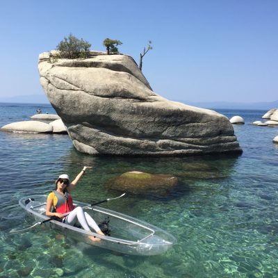 a person in a clear kayak adventure clearly enjoying blue Lake Tahoe water