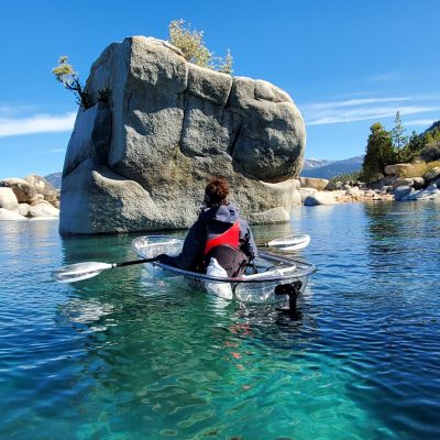 a person sitting on a rock next to water