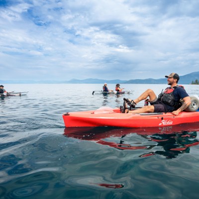 a group of people riding on the back of a boat in the water