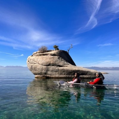 a man riding on the back of a boat in the water