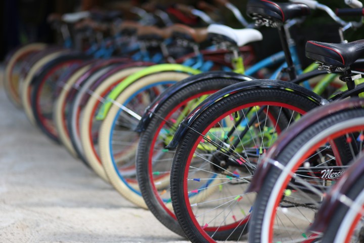 Row of parked colorful bicycles with focus on front tires.